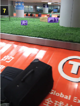Target image: a busy airport baggage area with several toy pandas, with the model's detections drawn over them.